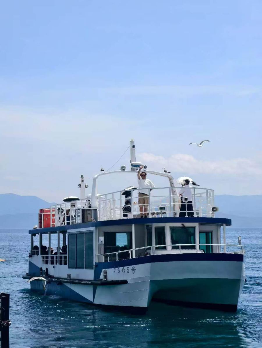 Guest waving from the Ine Bay cruise boat