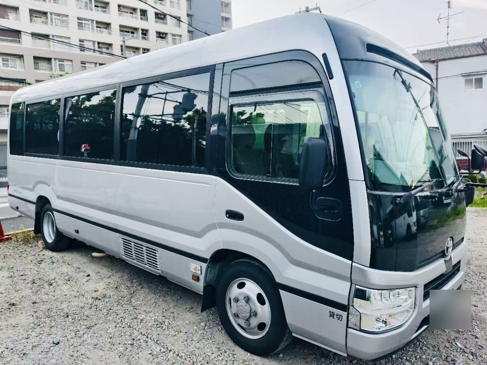 Silver Toyota Coaster micro-bus with charter plates
